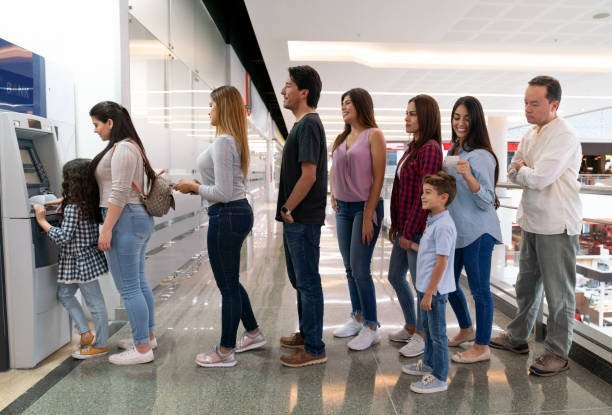 Consumers queue at an atm